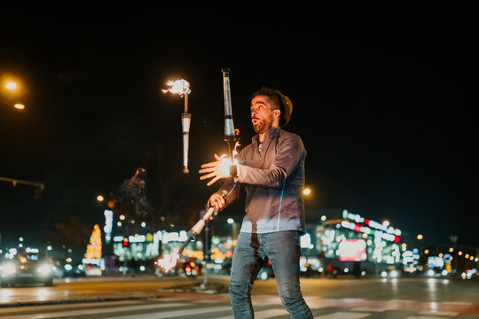 Street fire juggler performing dazzling show at night