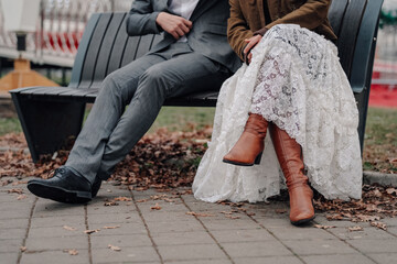 Couple celebrating wedding on bench during autumn