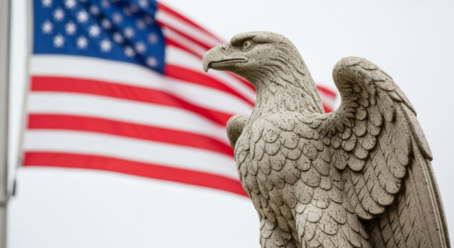 A majestic eagle statue stands proudly in front of the American flag, symbolizing strength and freedom against a cloudy backdrop.