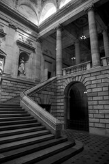 Obraz premium Grand neoclassical staircase interior with columns and statues, black and white