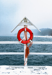 Fototapeta premium Orange lifebuoy on a wooden pier. Vacation at sea