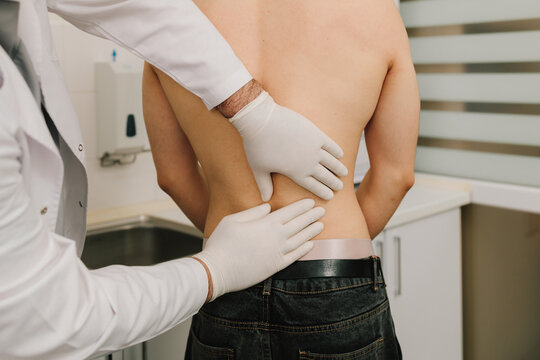 Patient undergoing renal palpation by urologist to evaluate kidney pain.