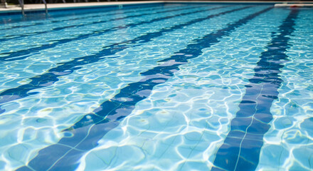 Obraz premium Image of a blue swimming pool with rippled water and dark lanes. Represents recreation, leisure, or aquatic activity for relaxation and exercise