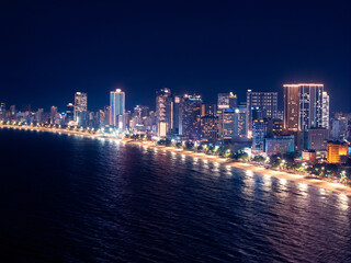 Obraz premium Aerial view Panorama of night cityscape with skyscraper neon light Nha Trang city Vietnam and bay of Sea.