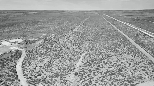 Scenic aerial photography of remote outback road leading to Exmouth with termite mounds and blue sky