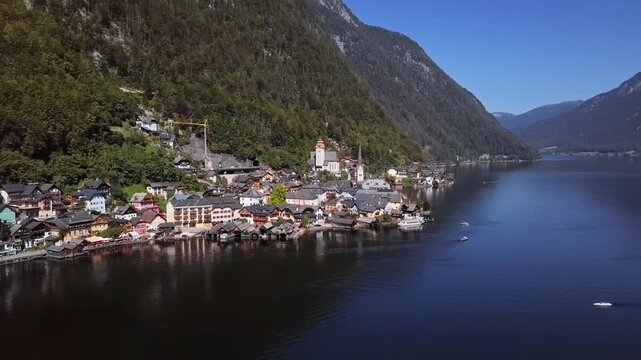Flight around Hallstatt village over calm Hallstatter See at sunny summer morning, in Salzkammergut, Upper Austria. 2.5x speeded up from 24 fps.