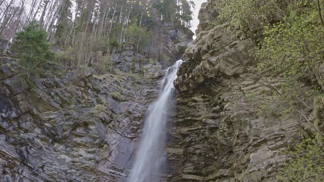 Waterfall in the mountains. Water falls from the from cascades. Top part of Diesbachfall waterfall, canton Glarus, Switzerland.