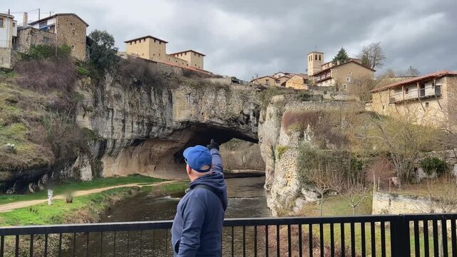 Hombre se&ntilde;alando al puente natural de Puentedey