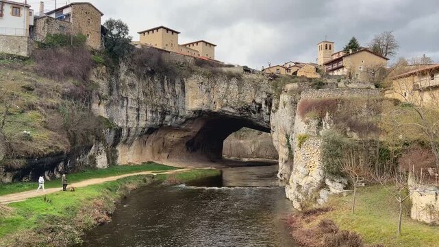 Puente natural de Puentedey con pareja paseando a su perro