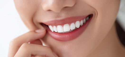 Naklejka premium Close-up of a young Asian woman displaying a radiant smile with perfect white teeth.
