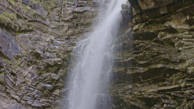 Waterfall in the mountains. Water falls from the from cascades. Top part of Diesbachfall waterfall, canton Glarus, Switzerland.