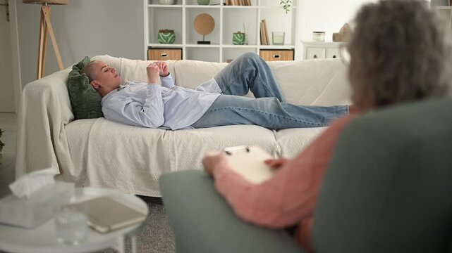 Person lying on couch during psychology session with therapist