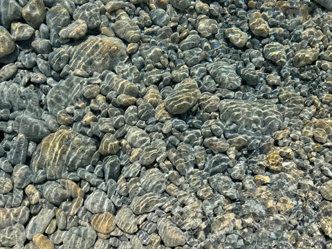 Pebbles and stones in transparent water natural background. 