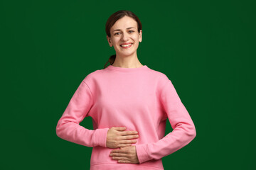 Woman with healthy stomach on green background