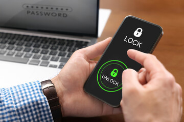 Privacy protection. Man signing into account with Password on laptop and unlocking mobile phone,...