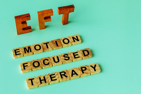 The acronym EFT and its individual words. Wooden letters and letters painted on wooden blocks. Emotion-focused therapy treatment concept.