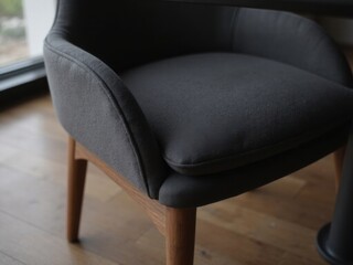 Gray Armchair in Modern Interior. A gray armchair featuring a wooden base situated in a stylish interior space.