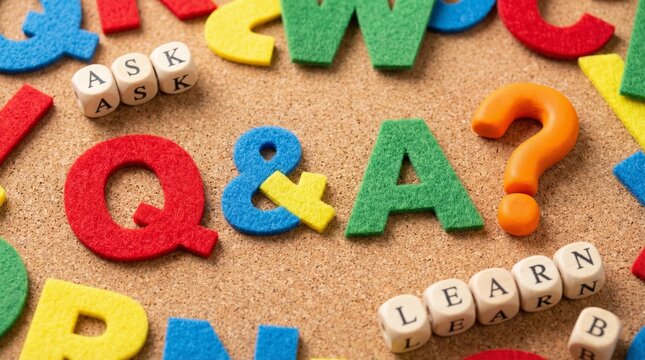 A colorful Q&A concept with educational letters and question marks laid out on a table surface
