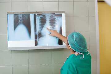 Obraz premium Backlit lightbox is displaying chest X-ray films on pale green tiled wall, pale yellow door