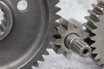 Macro shot of metal spur gears engaging, heavy duty steel gear transmission system and mechanical pinion assembly for industrial machinery engine.