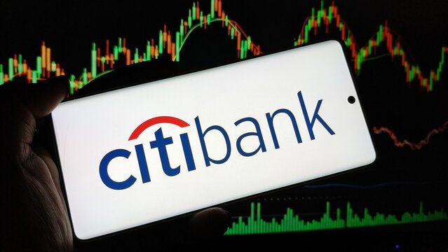 Citibank logo on smartphone with stock market graph background