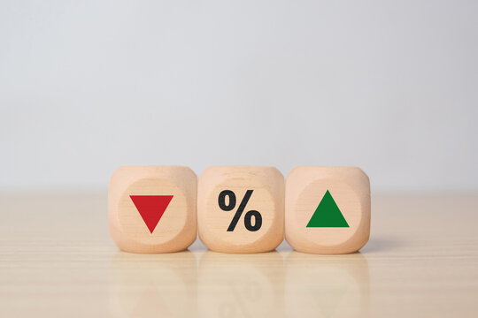 Wooden blocks with down arrow, percent symbol, and up arrow, representing financial indicators, percentage change, economic growth and decline, profit and loss, and business performance analysis