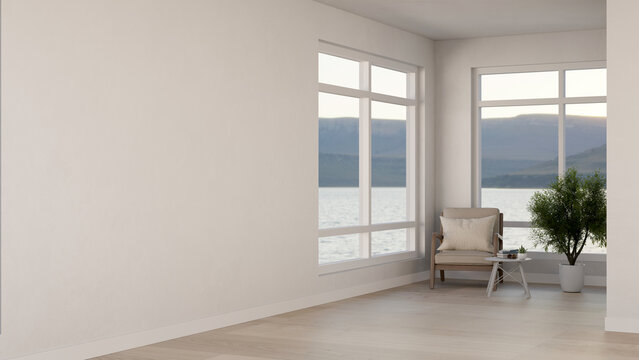 Armchair and table with potted plant on wooden parquet floor aside glass windows in white wall room.