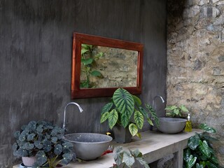 luxury outdoor sink area with natural stone wall and green plants in a hotel