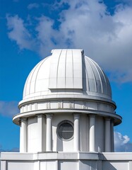 Close-up of a bright white domed building with circular window, tall columns and bright blue, cloudy sky