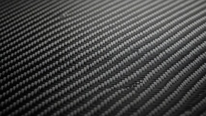 Close-up view of a dark woven carbon fiber pattern showcasing its strong and modern texture