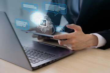 オフィスでノートパソコンとタブレットPCを使うビジネスパーソンとAI・人工知能のコンセプト
