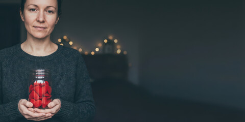 Hand jar love emotion thank with gratitude bokeh light charity care holiday concept valentine gift nubes feeling hopeful quiet room warm hearted woman sharing red heart candy as symbolic present