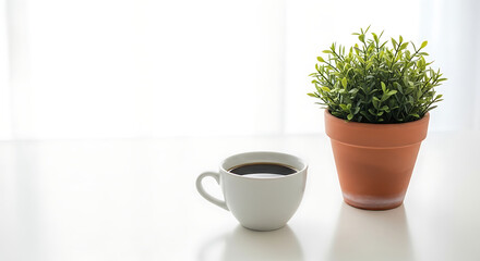 Fototapeta premium Minimalist Morning Scene with Black Coffee Cup and Potted Green Plant on White Table