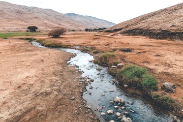 Dry, arid landscape with a small, flowing stream