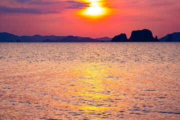 Golden sunset or sunrise over ocean horizon showing calm natural seascape waves sky background