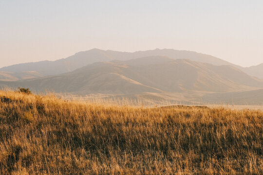 Film look landscape of Altay mountains at golden hour. Autumn steppe in East Kazakhstan with tonal perspective. Cinematic retro style, grainy texture, and warm nostalgic nature background.