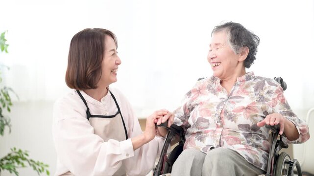 自宅で車椅子の母を介護をする様子　見つめ合う会話するコミュニケーションの在宅介護のイメージの動画　スローモーション