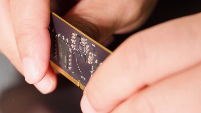 Hands Bending a Flexible Printed Circuit Board with Microchips