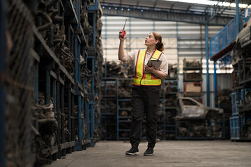 Automotive parts warehouse. Woman worker working in warehouse automotive parts warehouse, Checking...