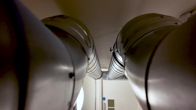 Metal Ductwork Pipes in Office Basement Ceiling Pair of Industrial Ventilation System Components Silver Metallic Finish Interior View Building Infrastructure