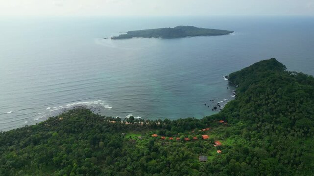 Flying over the forest overlooking the Inhame resort with beachfront houses and the turquoise sea, with Ilh&eacute;u das Rolas in the background.S&atilde;o Tom&eacute;,Africa.