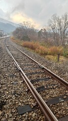 Obraz premium Railway Track with Mountain Landscape and Power Lines
