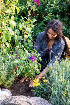 Woman planting flowers in her home garden