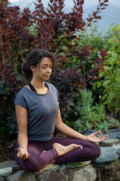 Young woman meditating in a yoga pose outdoors