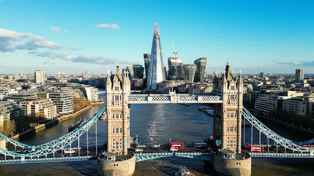 Aerial view of a bridge with towers, city skyline, and river. Sunny day, with tall buildings