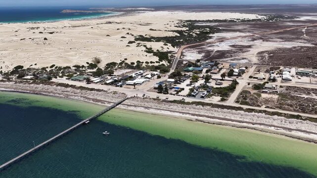 Fowlers Bay jetty, South Australia &ndash; 4K aerial drone view of Great Australian Bight coastline, caravan park, turquoise ocean, sand dunes, white sand beach and limestone cliffs