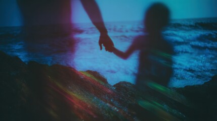 Fototapeta premium Blurred silhouette of adult and child holding hands at night by the ocean used for family health awareness or world kidney day campaign with artistic lighting