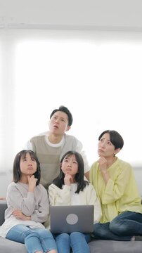 スマホを見ながら困った表情の小学生の女の子の家族