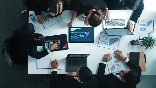 Top view of smart business people brainstorm marketing idea at meeting table while compare stock market investment data between laptop and tablet. Business team planning financial plan. Directorate.