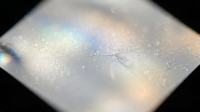 Macro Edge Diffraction Highlight the intricate details of light bending around individual film particles, creating shimmering, diffracted edges and subtle visual interest.